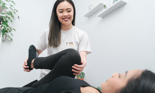Physiotherapist guiding patient in stretches.