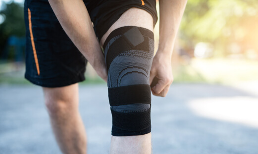 Man tightening compression sleeve on his knee.