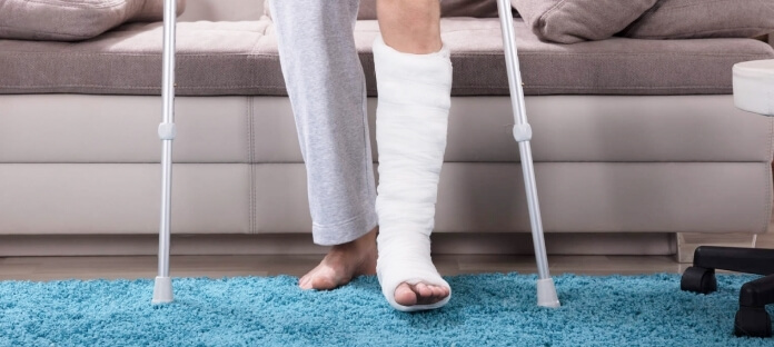 Person with bone fracture using crutches to walk.