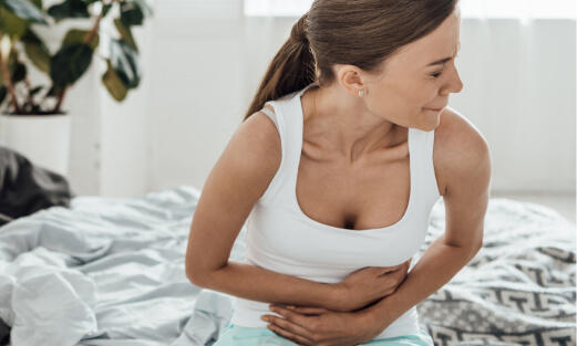 Woman with menstrual pain holding stomach.